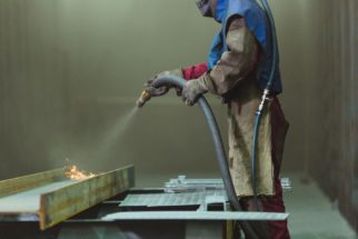 man performing abrasive blasting